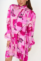 Close-up of Balenciaga pink silk shirt dress with fashion motif print and bow tie rental Malaysia