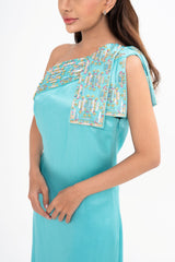 Close-up detail of the dress, highlighting the exquisite glittering embroidery detail and the turquoise fabric.