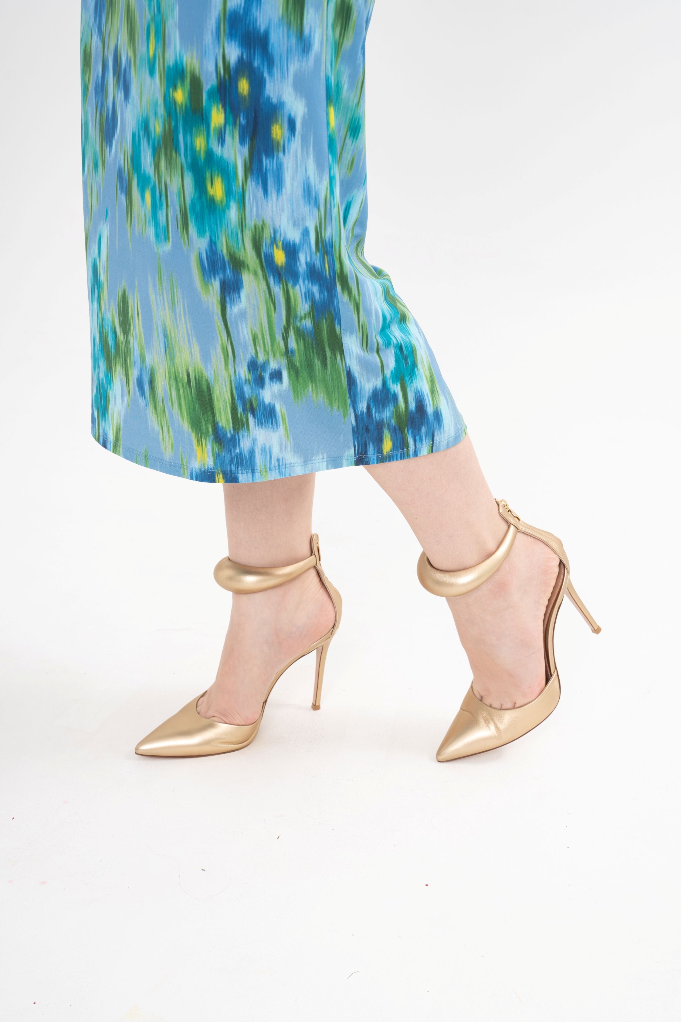 Close-up of the stiletto heel and ankle strap detailing, highlighting the texture of the gold Nappa leather.