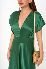 Close-up detail of the satin-crepe fabric, highlighting the rich emerald colour and the meticulous pleated texture.