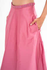 Close-up detail of the skirt fabric, highlighting the luxurious sheen of the Peonia Pink satin.