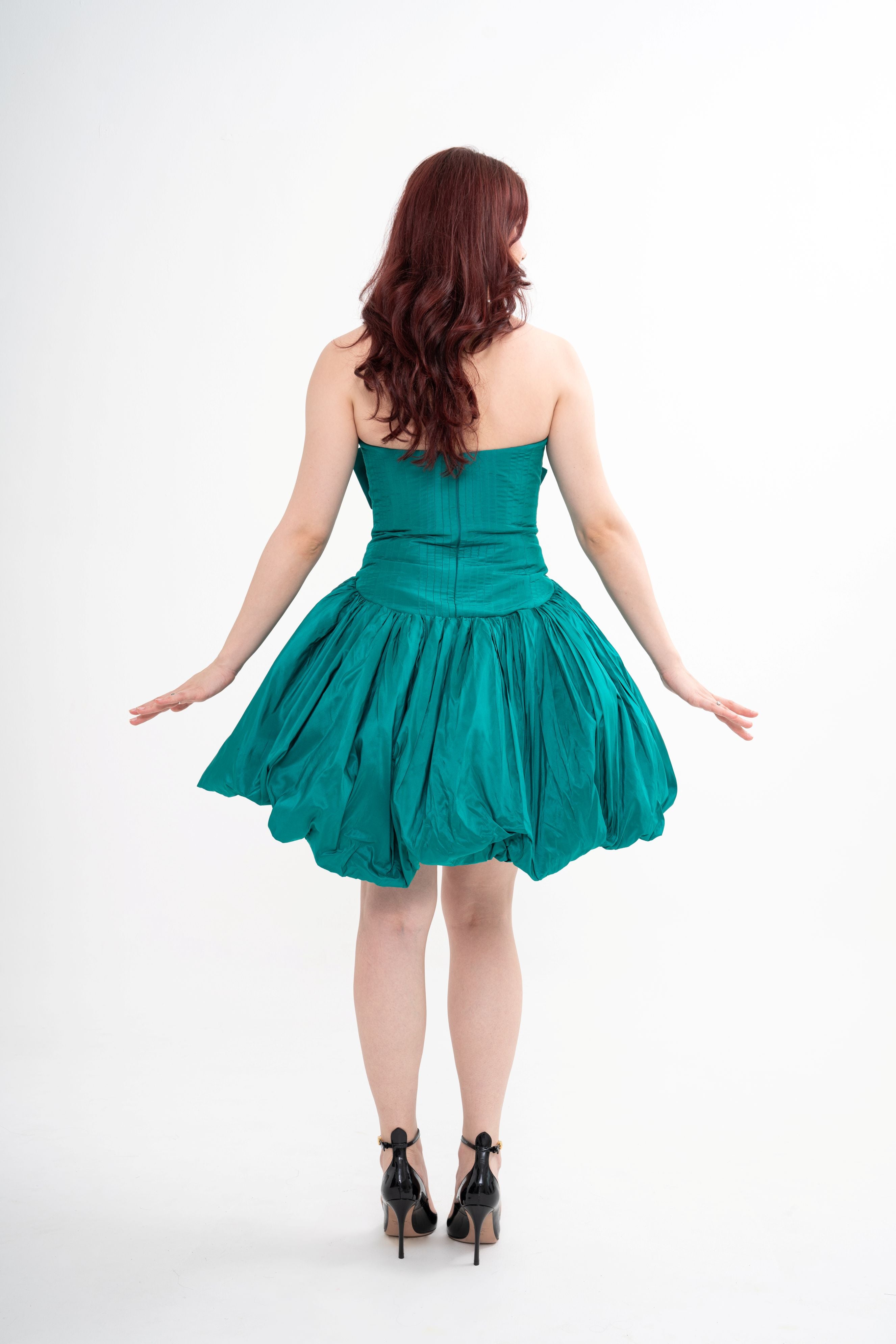 The designer dress styled, showcasing the structured fit, the playful gathered hem, and the short length