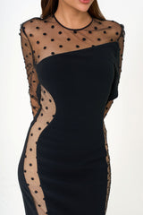 Close-up detail of the Swiss-dot pattern and the translucent tulle paneling on the designer dress.