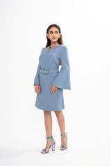 The designer dress styled with the detachable belt, showcasing the cinched waist and the elegant bell cuffs.