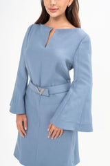 Close-up detail of the dress, highlighting the texture of the wool-silk crepe fabric and the crystal logo embellishment.