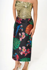 Close-up detail of the skirt fabric, highlighting the luxurious silk-blend texture and the shimmering metallic threads within the parrot print.