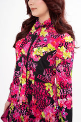 Close-up detail of the dress, highlighting the texture of the crepe fabric and the fine pleated detailing.