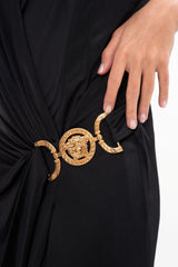 Close-up of the dress bodice, highlighting the wrap-style V-neck and the detailed gold Medusa emblem, photographed in Sri Hartamas, Malaysia.