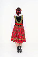The vibrant floral headpiece (crown of blooms) and the full skirt detailing of the Cracow ensemble.