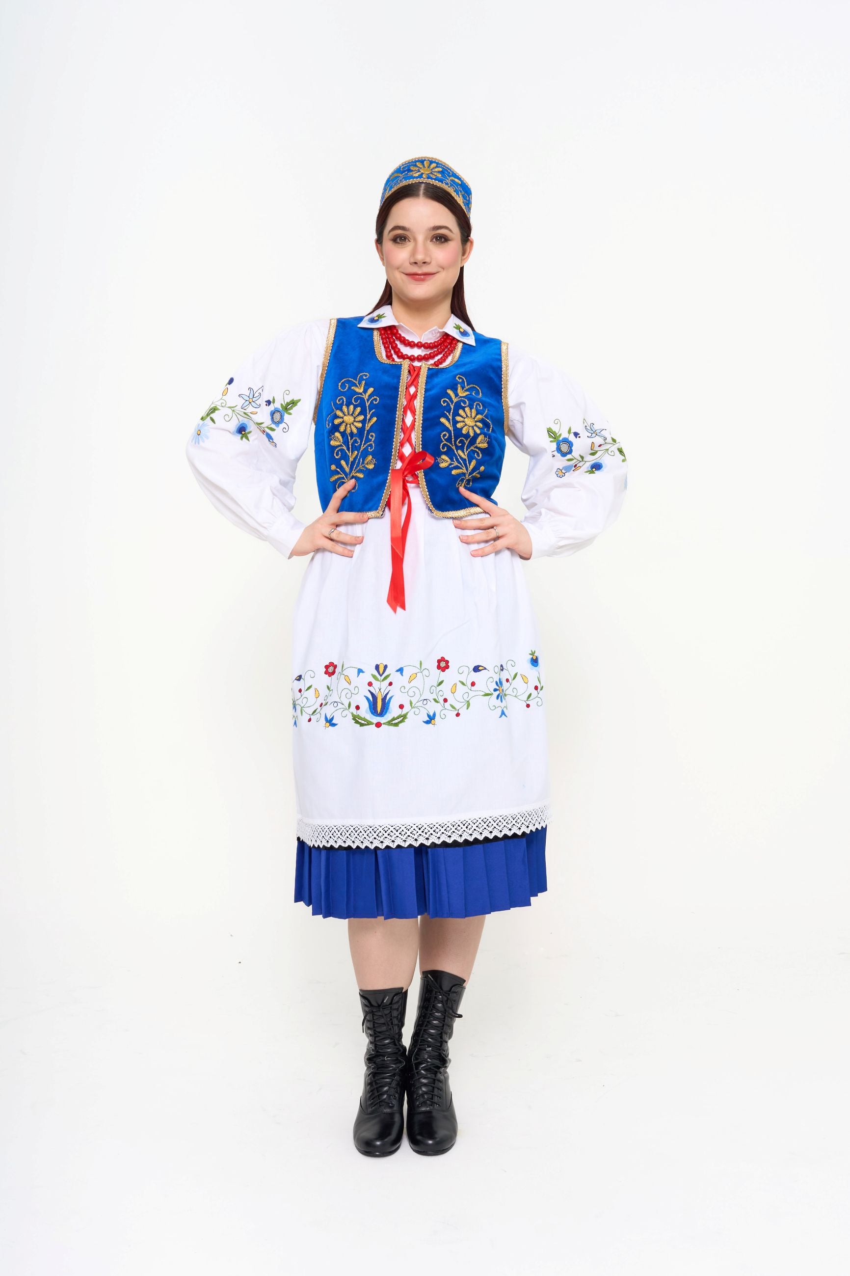 Close-up detail of the embroidered blue vest, highlighting the gold thread and red ribbon tie.