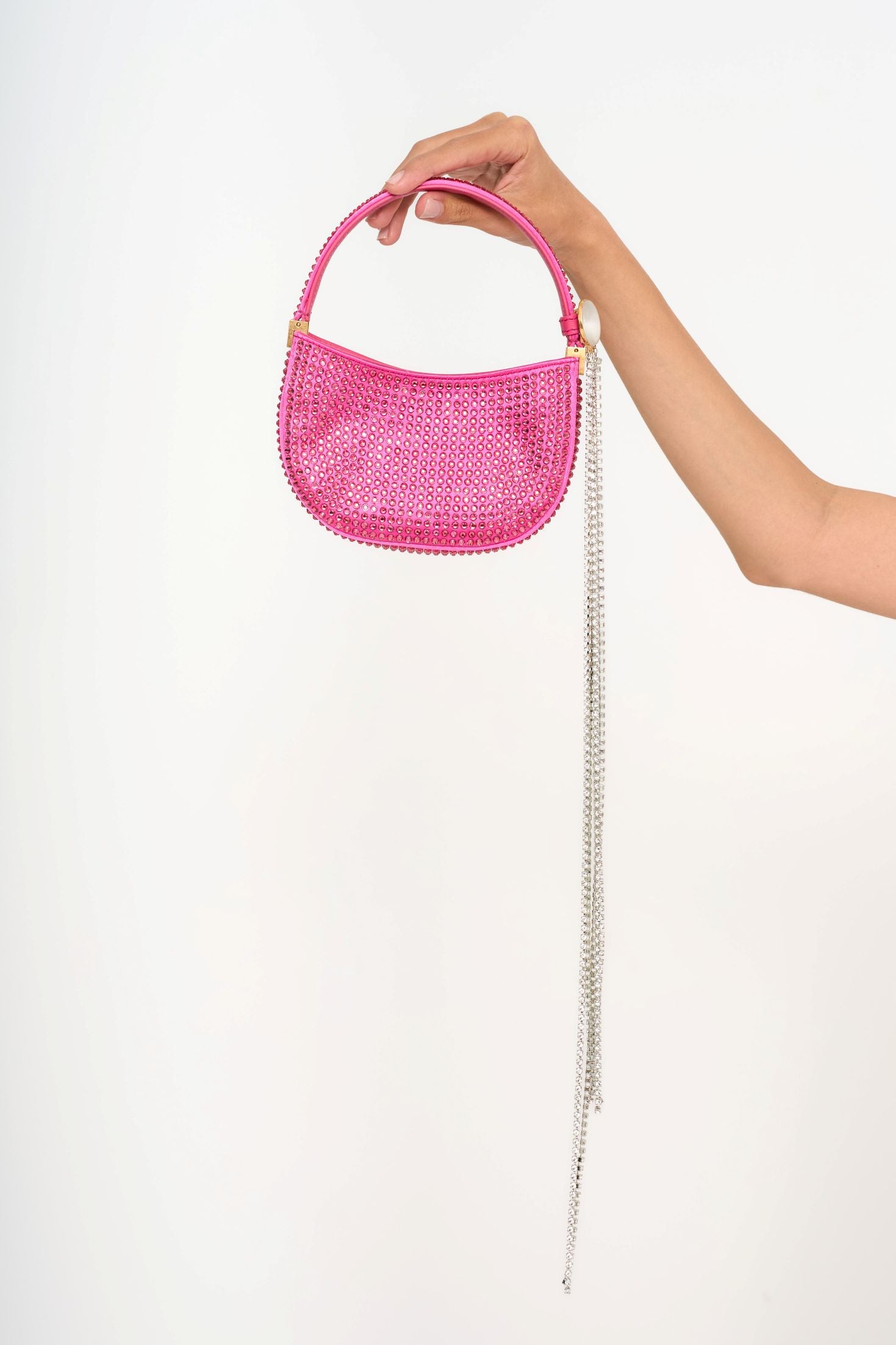 Close-up detail of the detachable enamel brooch with light-catching crystal fringe, showing the gold hardware contrast